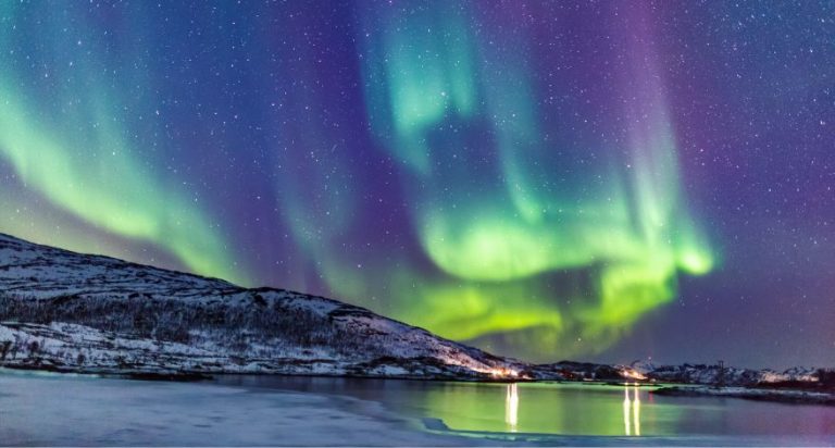 The Northern Lights over a small coastal town.
